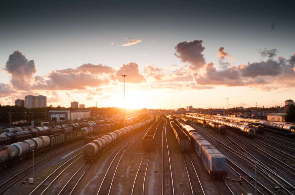 Train yard in foreground with a setting sun in the background