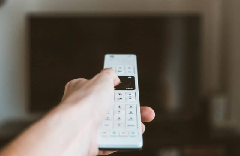A hand holding a smart TV remote