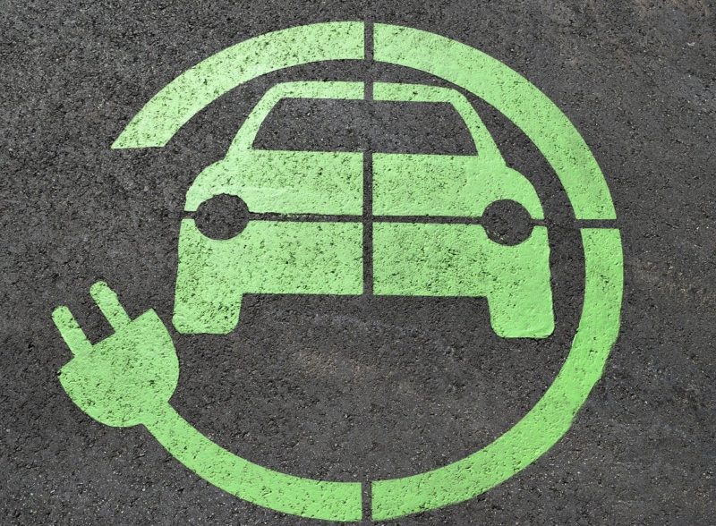 Green icon of a car surrounded by an electrical cord
