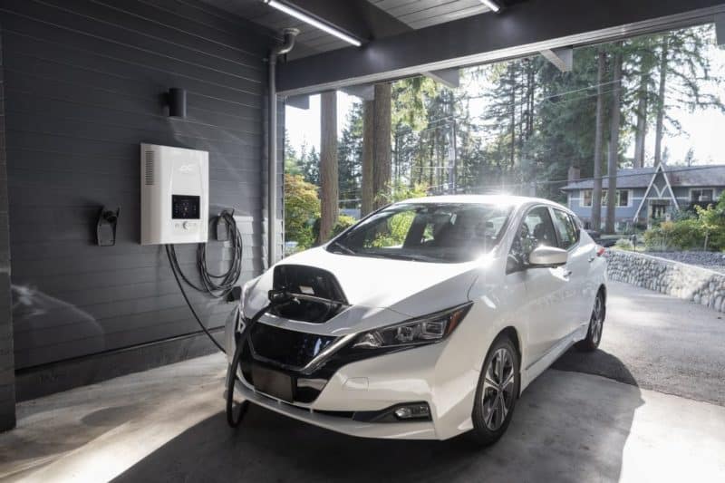 a white electric car charging in a garage near Vancouver, BC